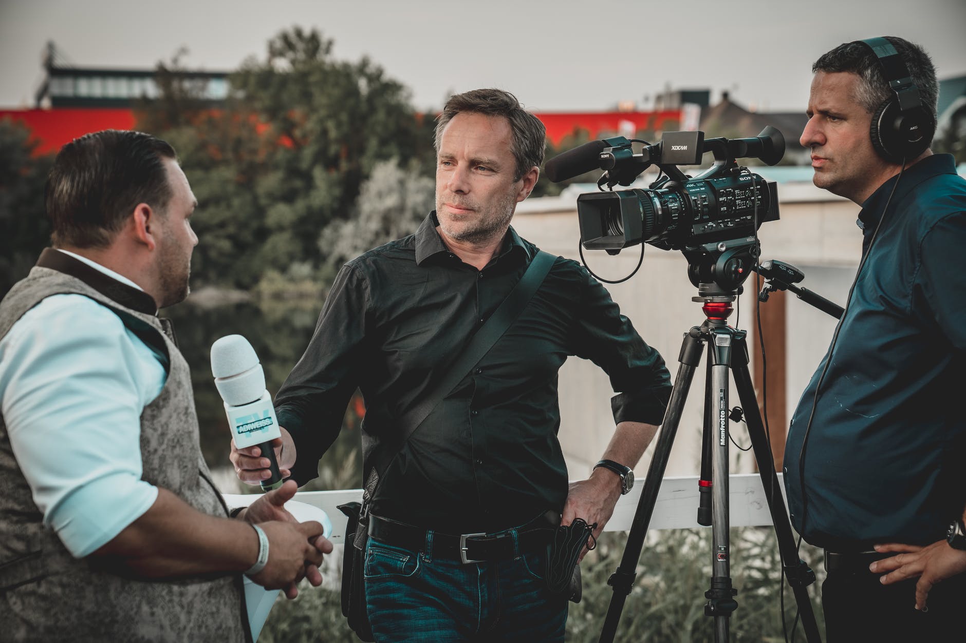 man holding microphone while talking to another man